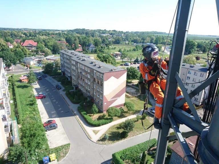 Montaż instalacji przemysłowych, spawanie na wysokościach, pracownik na wysokości w masce spawalniczej, Climbnet